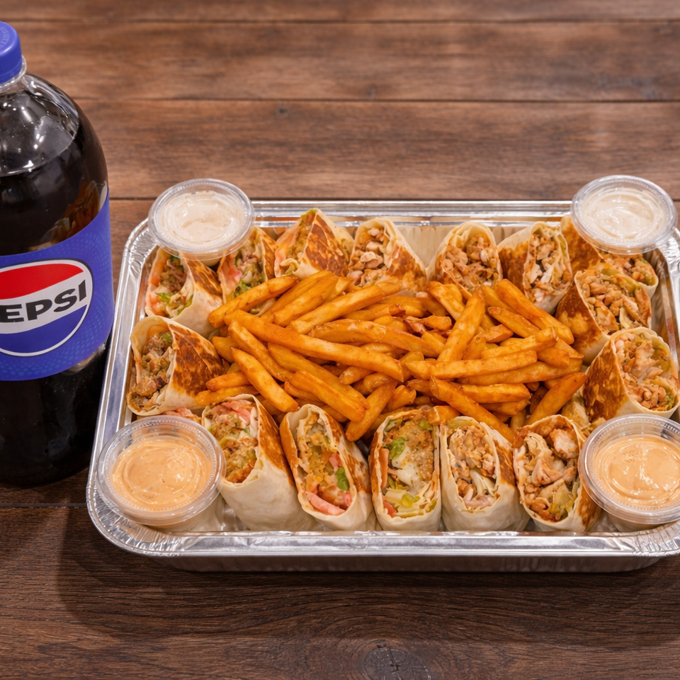 Aluminum tray of sliced chicken wraps, seasoned fries, and four dipping sauces beside a large Pepsi bottle on a wooden table.