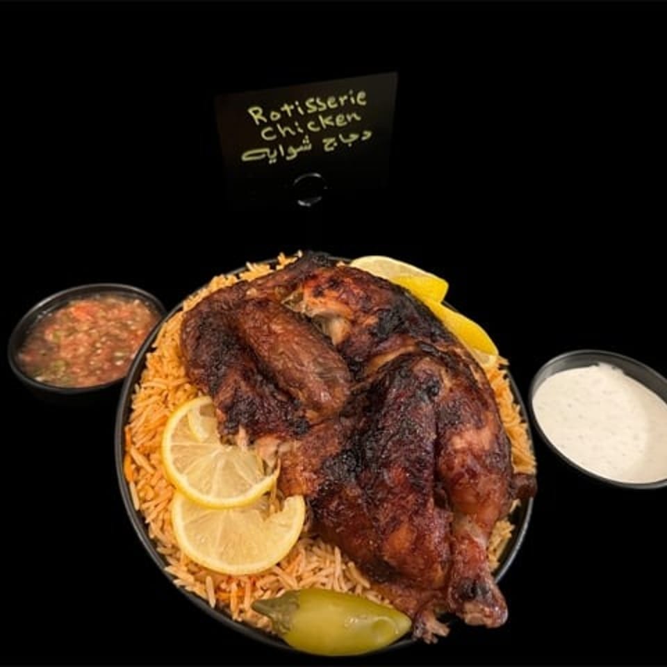 Char-grilled rotisserie chicken served over seasoned rice with lemon slices, green chili, and dipping sauces.
